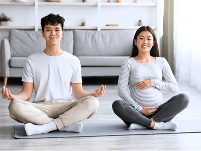 一位孕婦和她的丈夫在練習冥想。這篇博客分析了懷孕如何影響孕婦的睡眠品質。